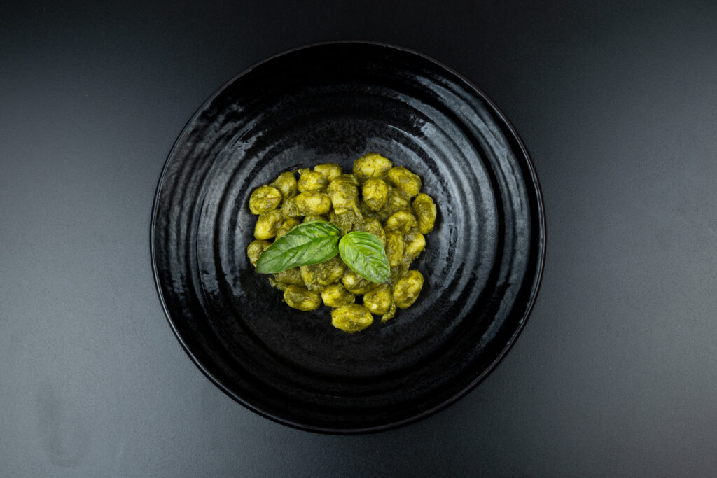 Soft potato gnocchi coated in aromatic basil pesto and Parmesan cheese, served at The Meet Up in Cascavelle, Mauritius.