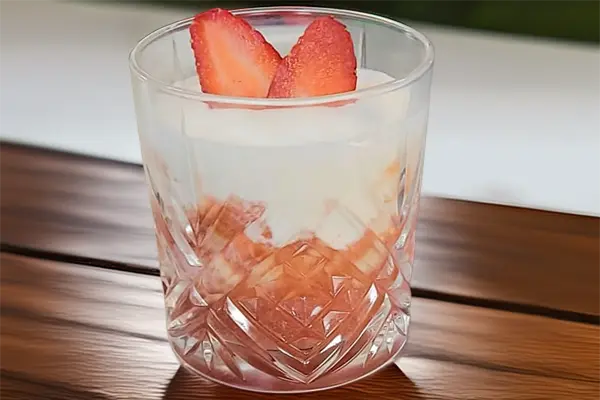 Strawberry Cappuccino dessert with strawberry purée, pistachio ice cream and whipped cream in a glass